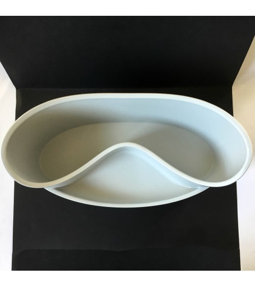 Vide-poche en caoutchouc gris clair à deux compartiments.